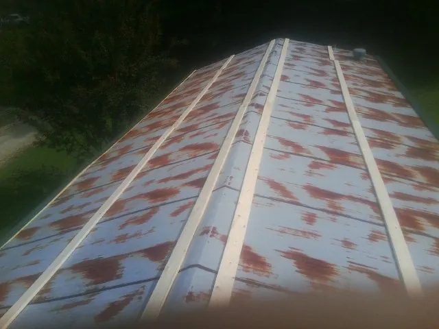 Rusted metal roof panels with new wood purlins before replacement — Storm Damage Roof Repair in Manhattan by Roofing Brothers