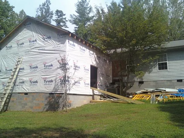 Tyvek wrapped gable on a new room addition beside an existing home in Manhattan