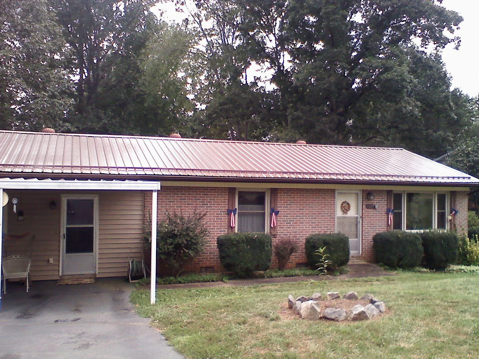 Bronze metal roof and carport on a brick ranch home — Roof Repair work by our crew in Manhattan