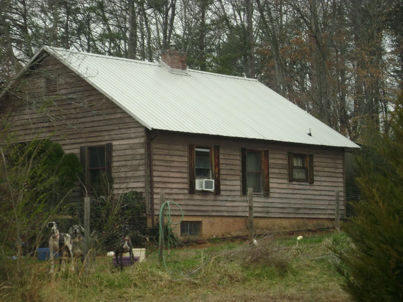 White metal roof on an old wood sided farmhouse, from a Asphalt Shingle Roof Repair job in Manhattan